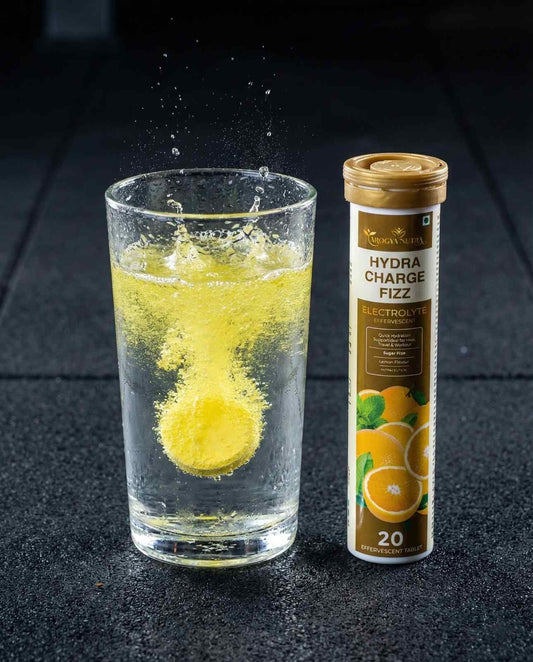 Glass of lemonade with a Hydralyte tube on a dark surface