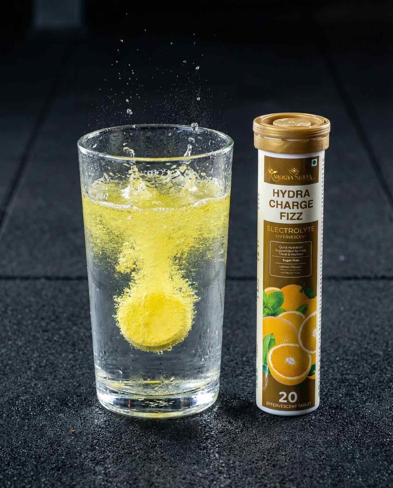 Glass of lemonade with a Hydralyte tube on a dark surface